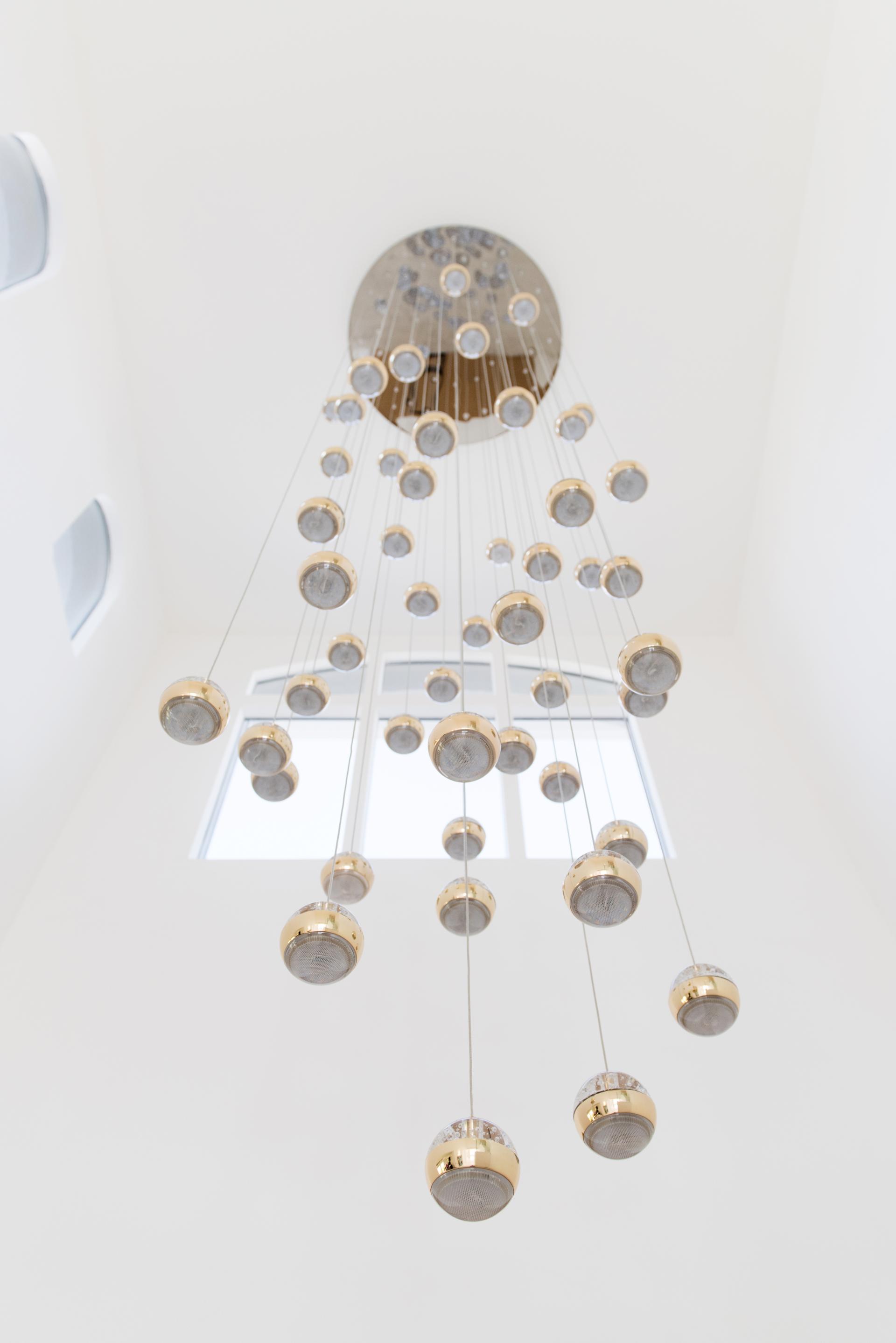 Elegant minimalist chandelier composed of suspended glass globes, enhancing the serene atmosphere of a modern Palm Jumeirah residence.