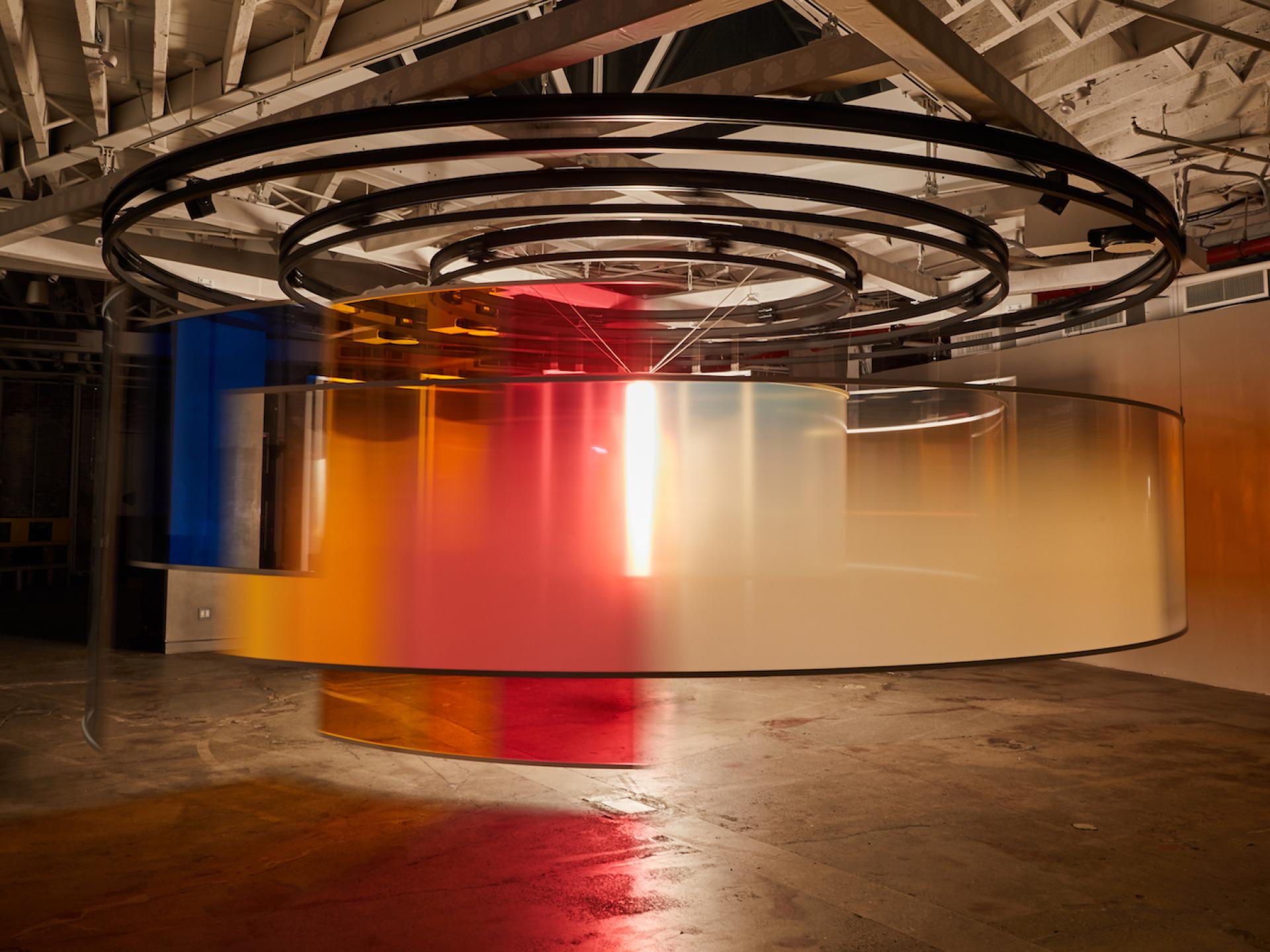 Vibrant urban art installation featuring colorful translucent discs, celebrating MINI's electric vehicle launch at an exhibition.