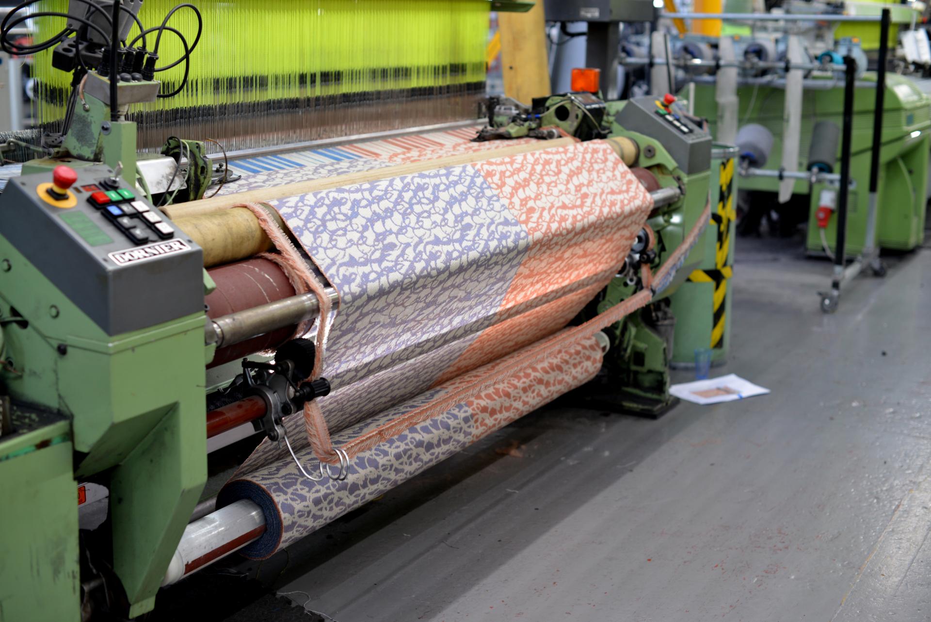 Textile weaving machine operating with patterned wool fabric, illustrating the transformation of British wool at Yorkshire Sculpture Park.