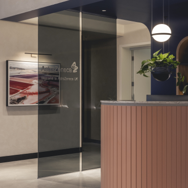 Modern reception area of AstraZeneca UK featuring a stylish front desk and artistic wall decor by Ekho Studio.