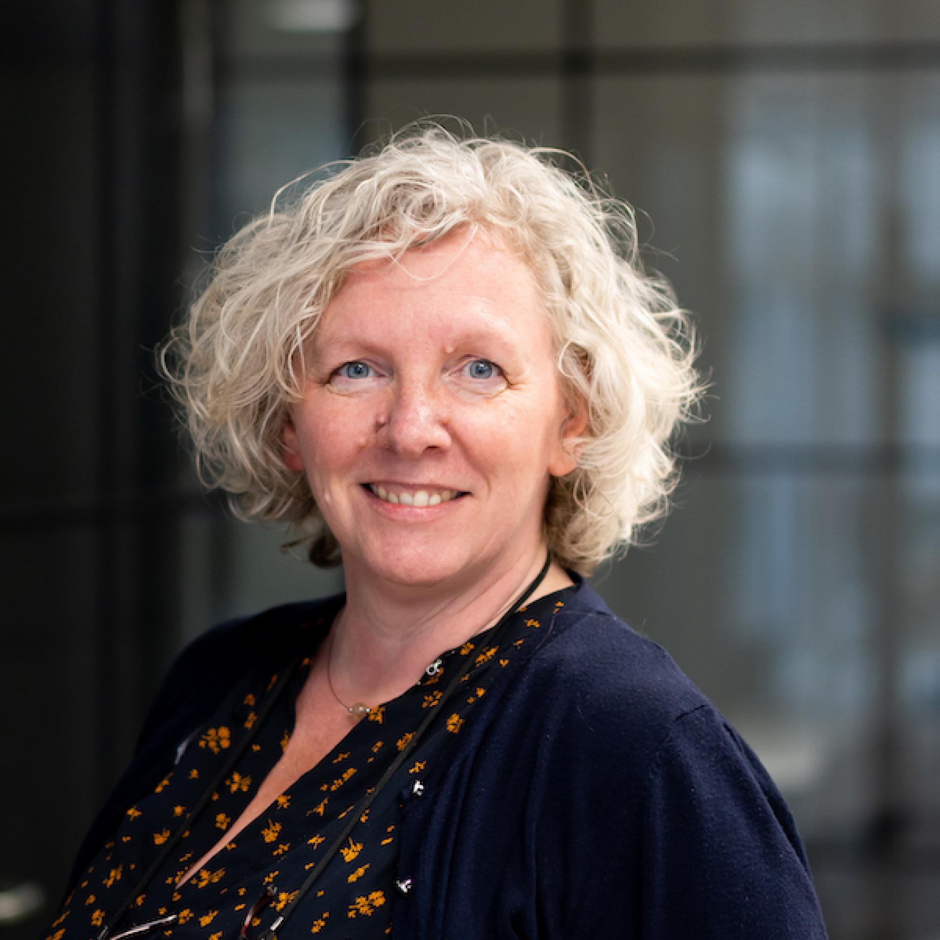 Professional woman smiling in a modern office, representing innovation and collaboration in a forward-thinking workplace.