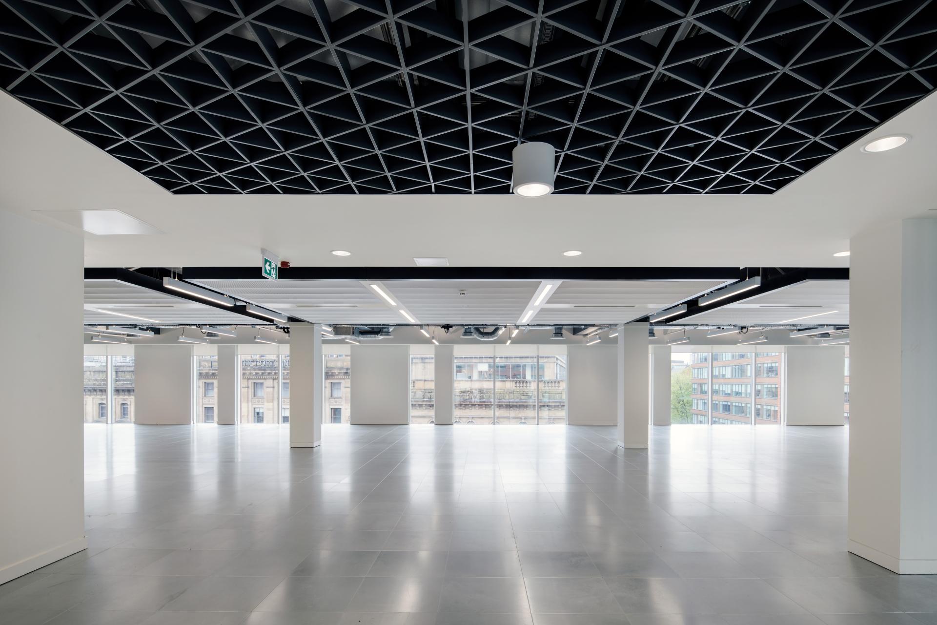 Modern office space at One Piccadilly Gardens, showcasing a sleek design with ample natural light and geometric ceiling.