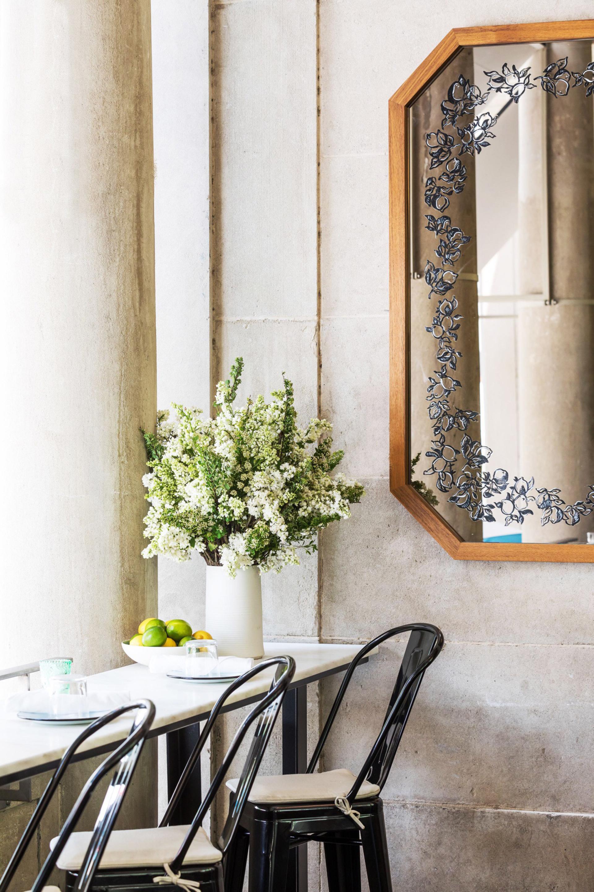 Brightly decorated interior of Bocce with flower arrangement, modern mirror, and stylish seating in Union Square.