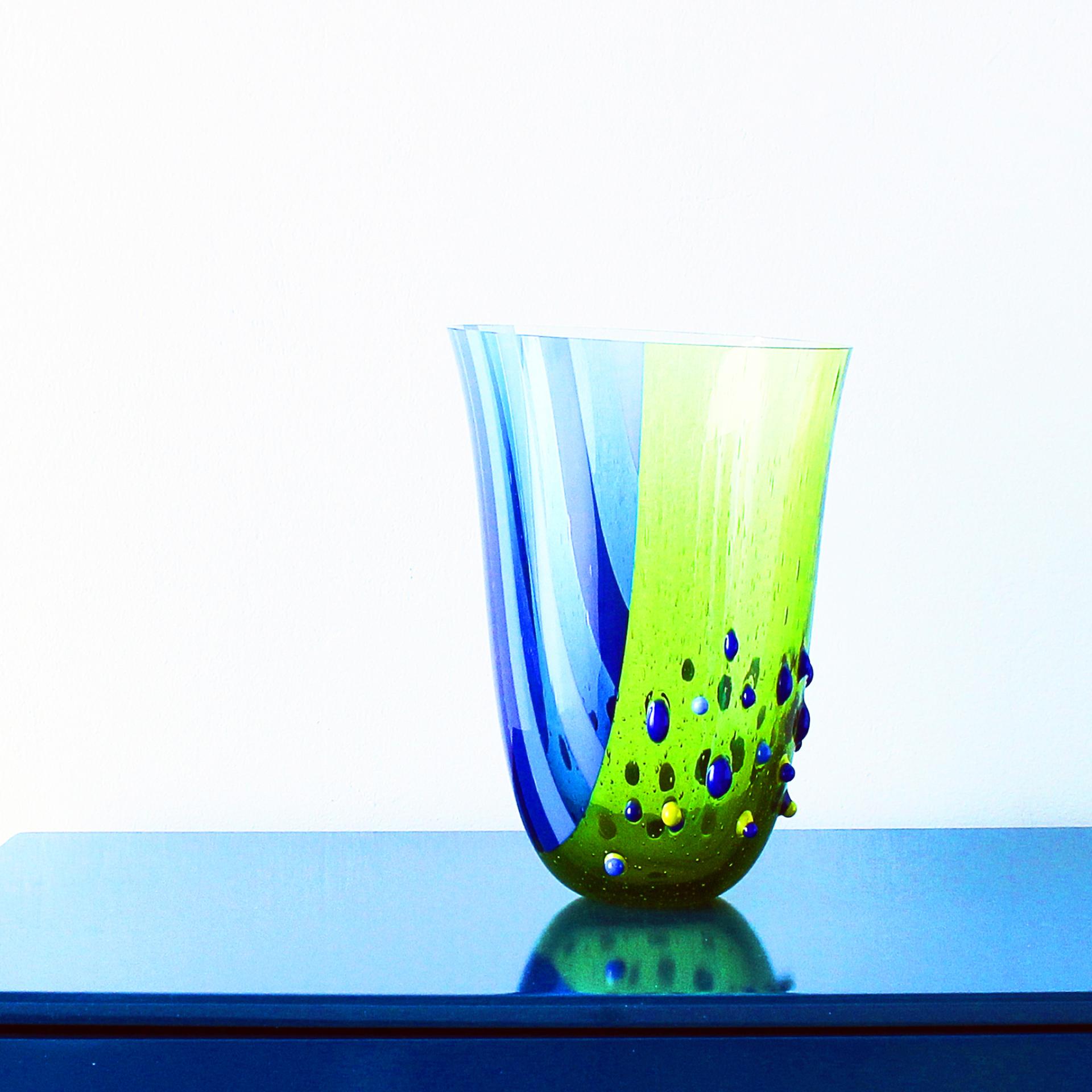 Colorful glass vase with green and blue swirls, showcasing intricate bubbles, representing creative craftsmanship in North West England.