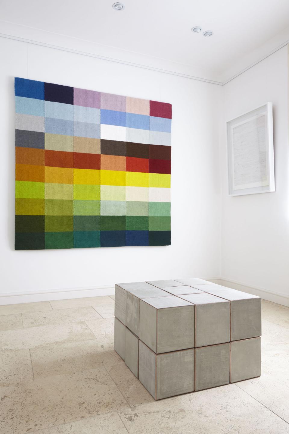 Textile artwork titled 'Wiltshire Landscape Tapestries' featuring vibrant color blocks, displayed alongside a modern concrete sculpture.