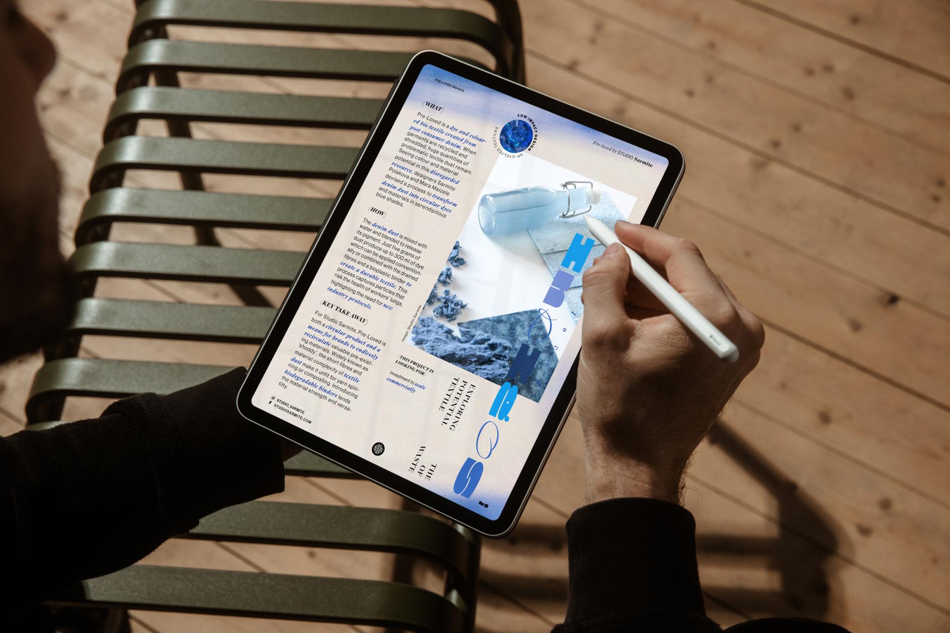 A person using a tablet to explore materials and design concepts related to color and circularity in the built environment.