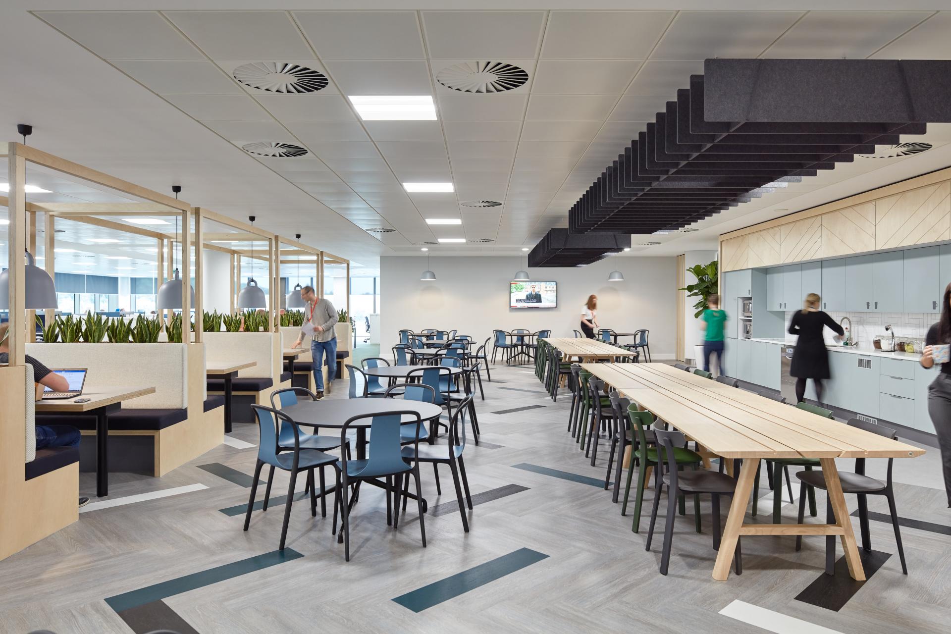 Modern office kitchen and dining area designed for healthcare professionals, featuring collaborative workspaces and stylish decor.