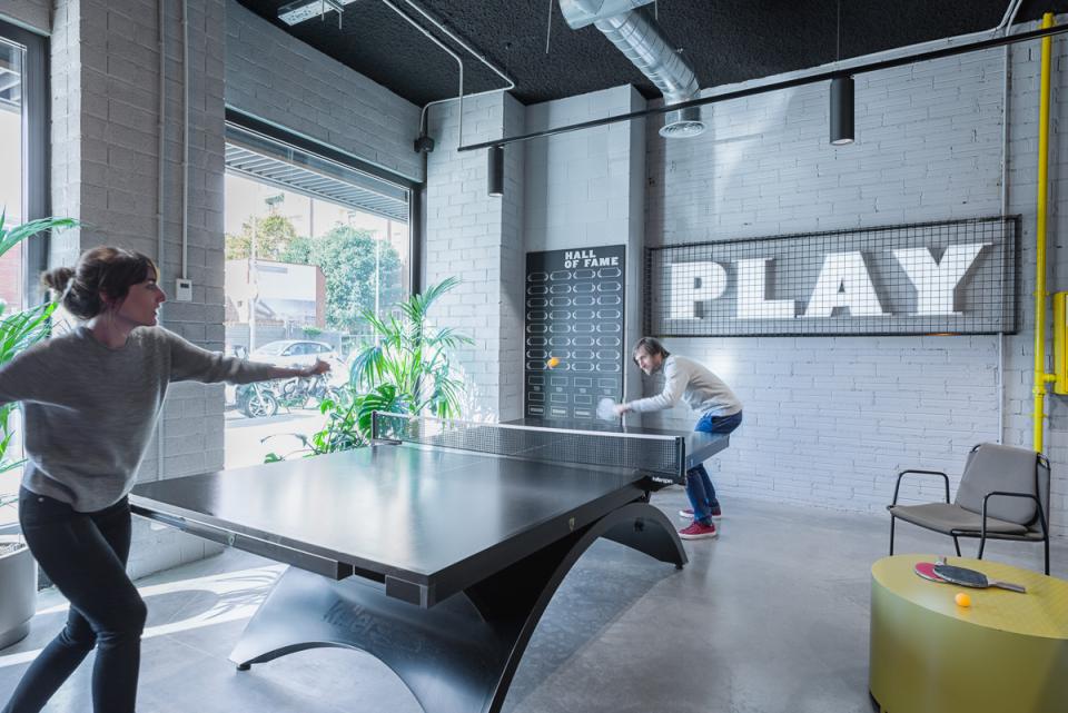 Co-living space at The Student Hotel Barcelona featuring residents engaging in friendly ping pong match in a vibrant setting.