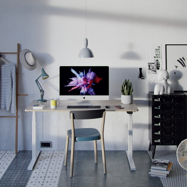 Modern home office setup featuring a Hi-Lo desk, computer, ergonomic chair, and decorative items for workplace wellbeing.