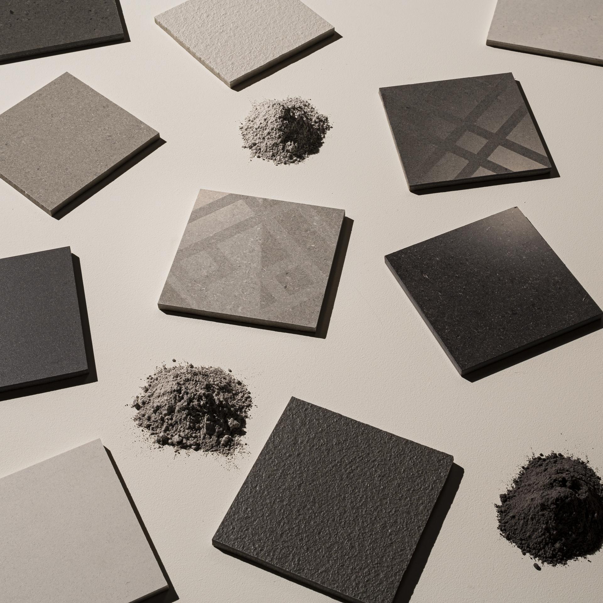 Collection of gray and black tiles with corresponding powder materials, showcasing the elegant designs of Parkside's Regal Collection.