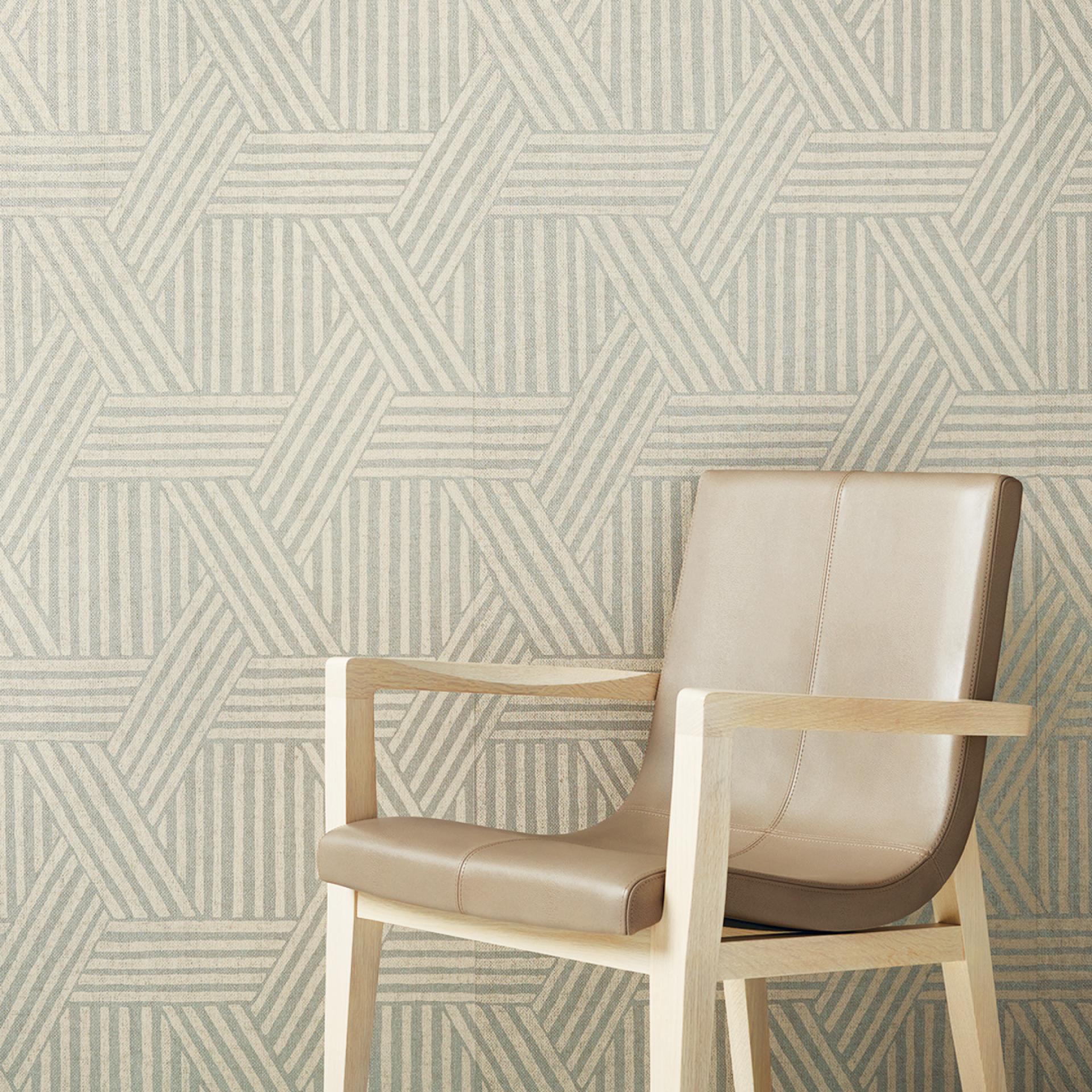 Stylish leather chair positioned against a geometric patterned wallcovering from HOLLY HUNT’s new portfolio launch.