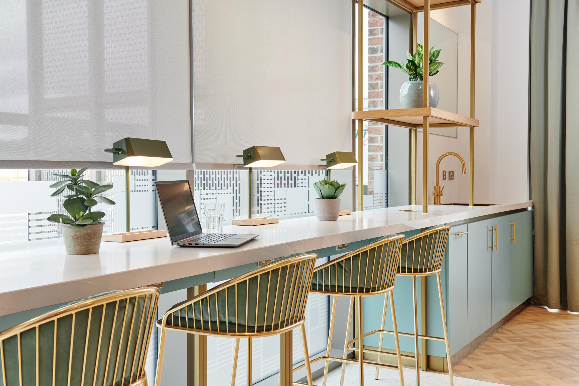 Modern coworking space featuring stylish seating, plants, and a laptop, designed for Grainger's residential development in Leeds.