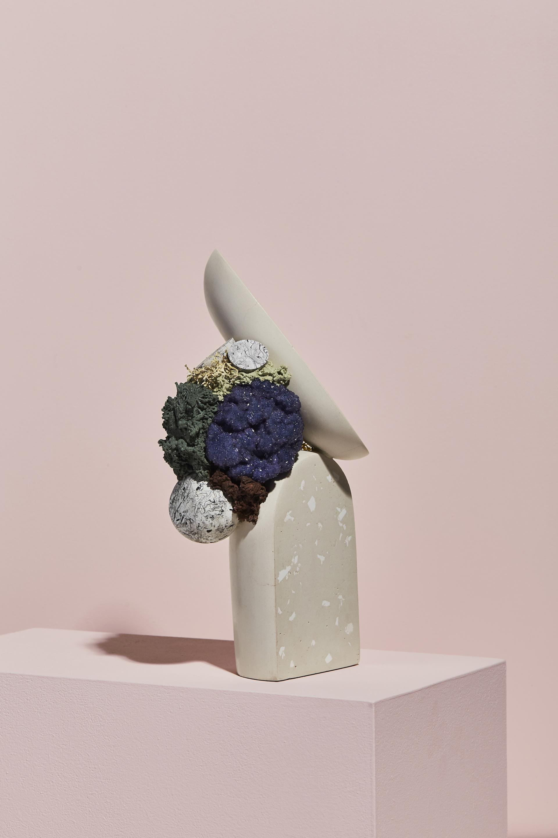 Modern abstract sculpture featuring textured colors and organic shapes, showcased against a soft pink background.