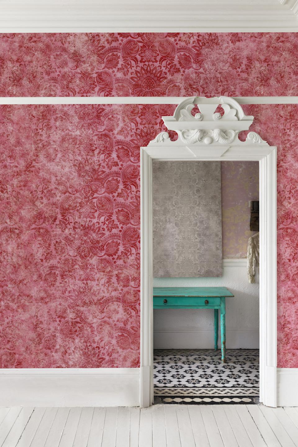 Traditional V&A wallpaper design in a pink room, showcasing a decorative mirror and turquoise table against patterned flooring.