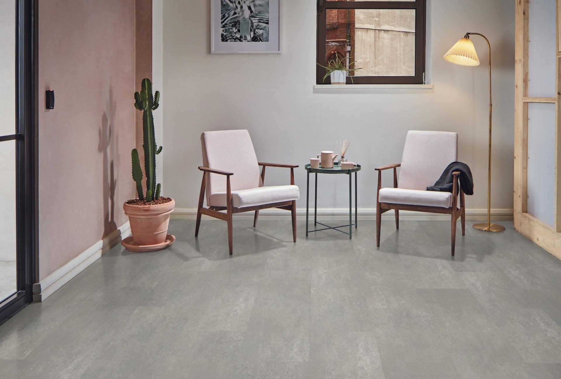 Contemporary room featuring Karndean Knight Tile flooring, two armchairs, a potted cactus, and stylish decor elements.