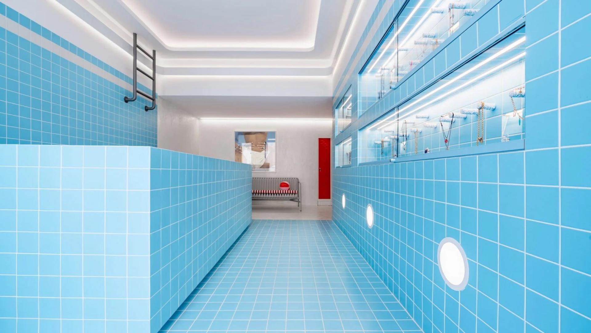 Vibrant blue tiled interior resembling a swimming pool, showcasing jewelry displays in a Mykonos shop.