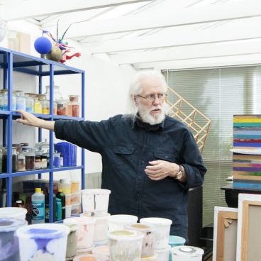 Finn Sködt gestures towards a colorful array of paints and art supplies in his studio for Kvadrat's Divina Melange range.