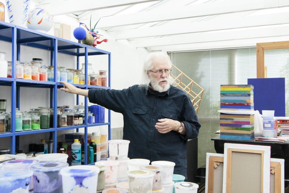 Finn Sködt gestures towards a colorful array of paints and art supplies in his studio for Kvadrat's Divina Melange range.