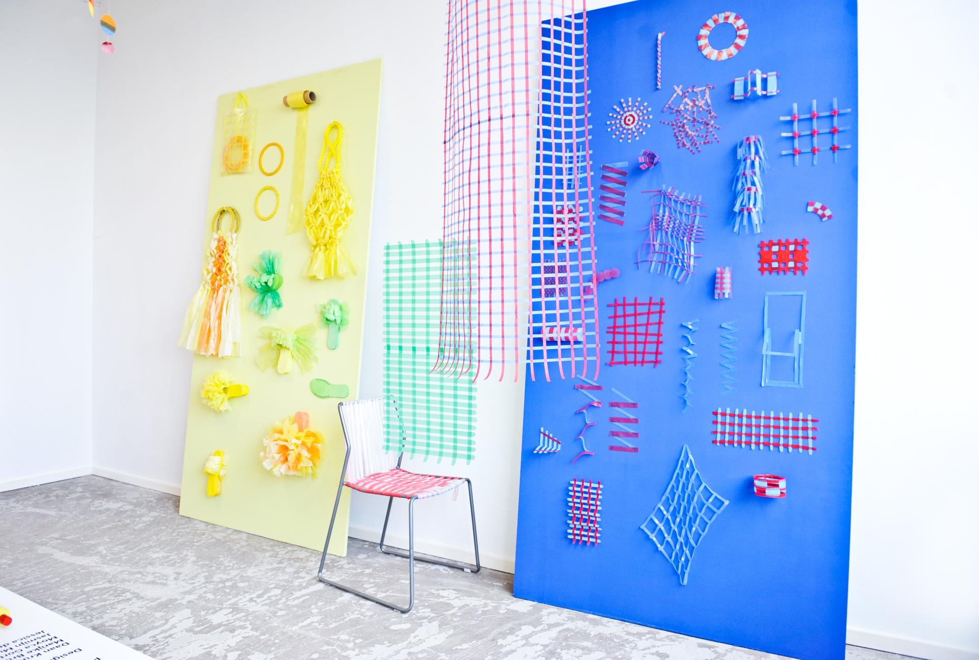 Colorful wall displays of recycled plastic designs and a chair, showcasing Jessica den Hartog's innovative approach to material and collaboration.