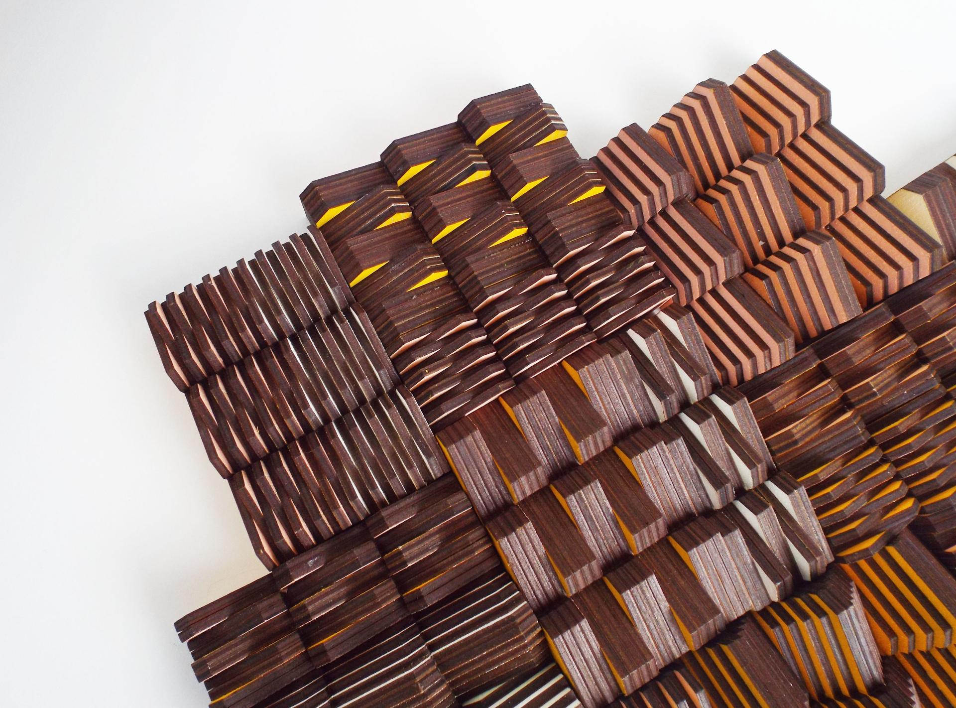 Artistic arrangement of layered wooden samples showcasing various textures and colors at the Surface Design Show 2022.