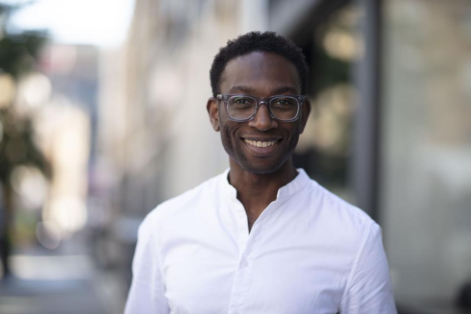 Head of design Paul Dare smiles warmly outdoors, showcasing his commitment to innovative workplace design and technology.