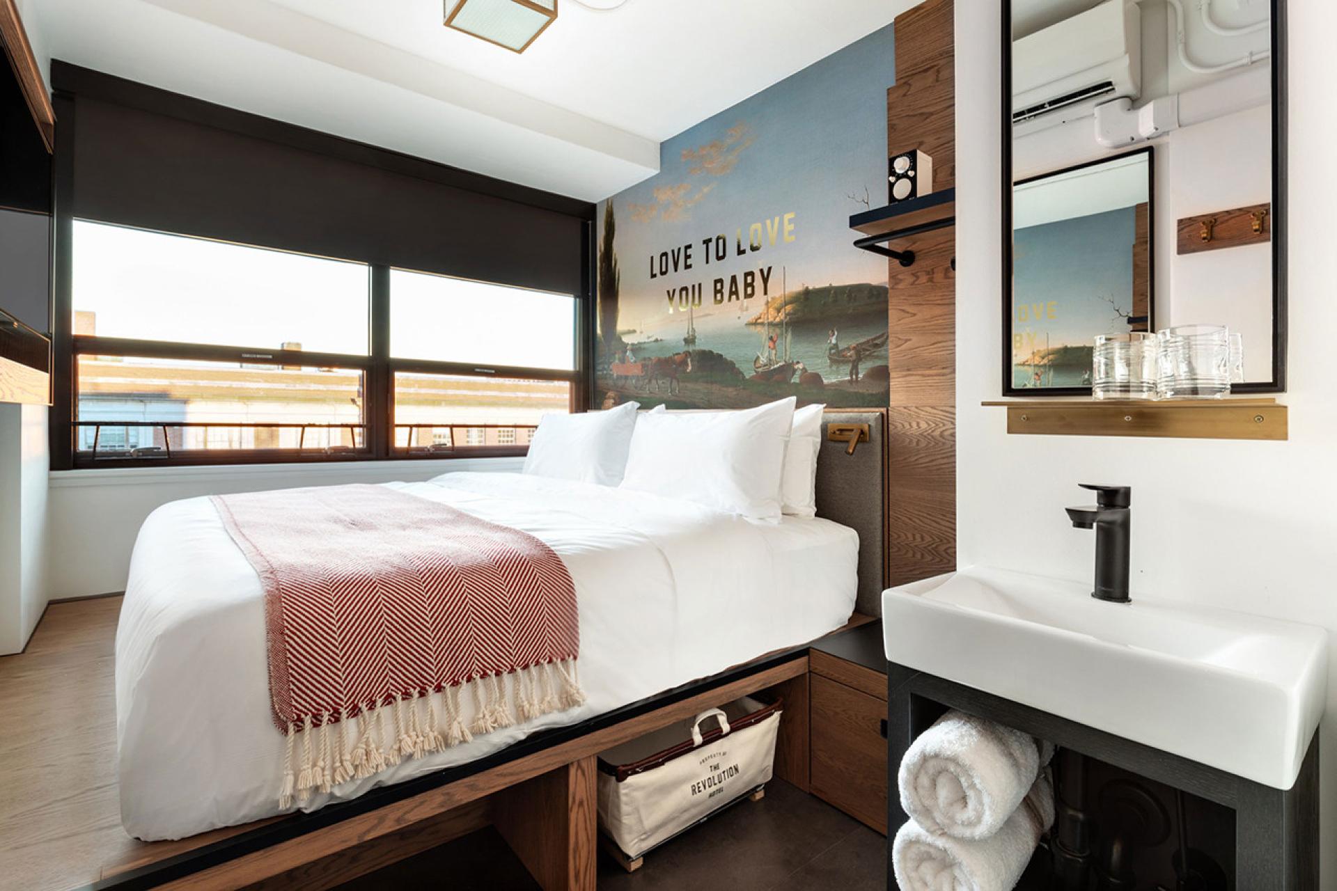 Stylish hotel room at The Revolution Hotel, showcasing modern design elements and a mural inspired by Boston's heritage.