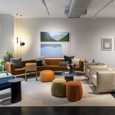 Modern seating area in NaughtOne's flagship London showroom featuring vibrant furniture and art decor, showcasing innovative design.