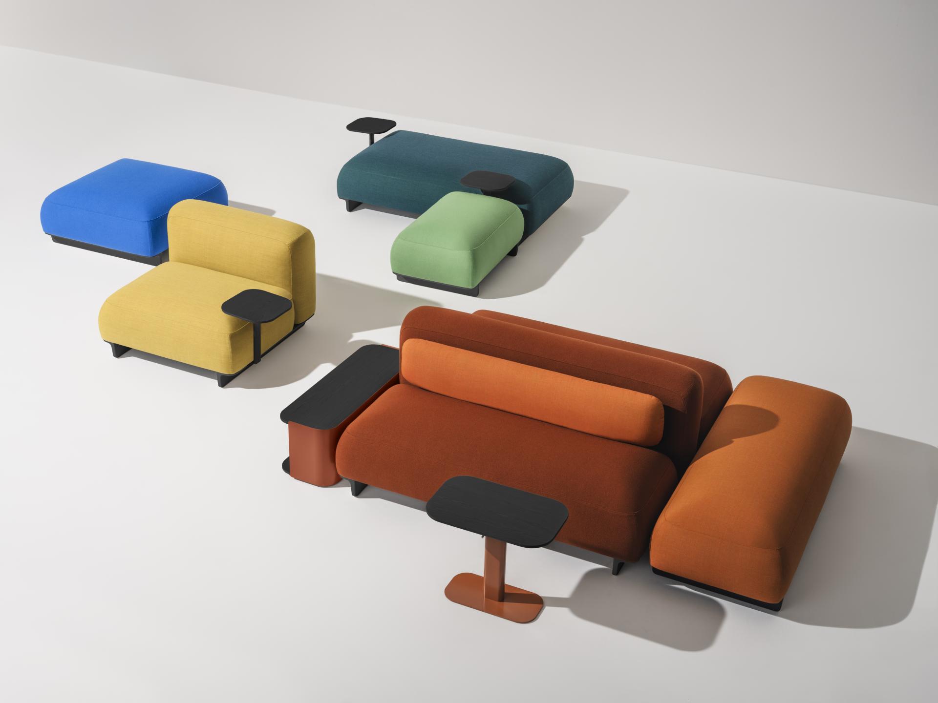 Colorful modular sofas with integrated side tables displayed creatively for innovative design at Clerkenwell Design Week.