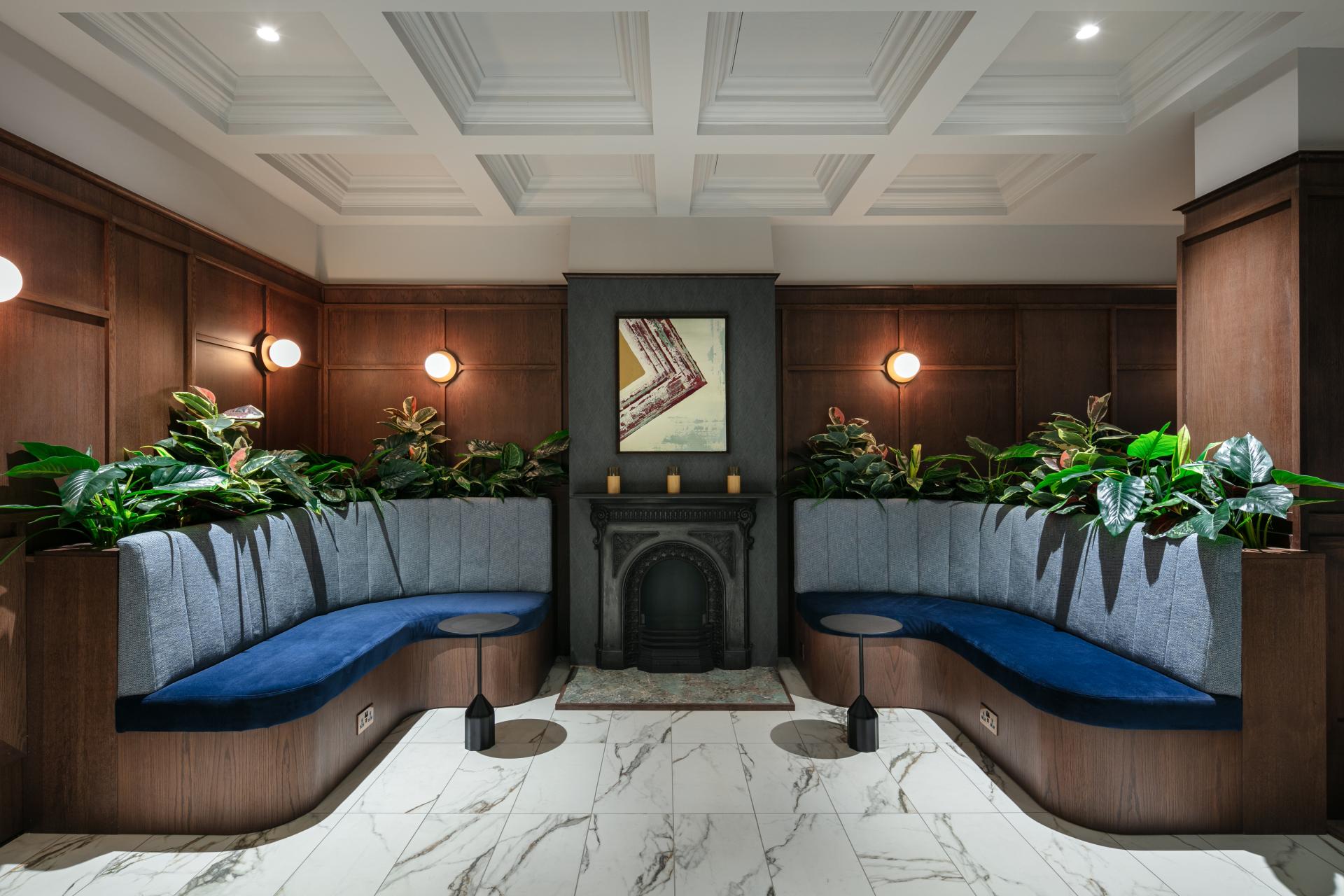 Stylish workspace featuring plant-filled seating areas, elegant lighting, and artistic decor, reflecting modern design principles by AXI Studio.