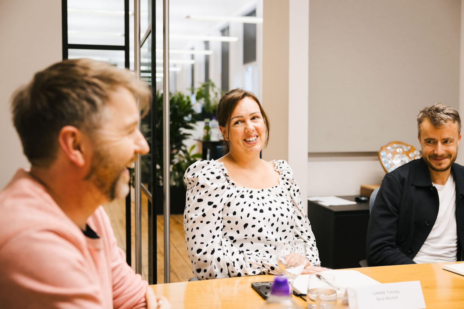 Professionals engaging in a discussion on Glasgow's property outlook during a seminar, with a focus on collaboration.