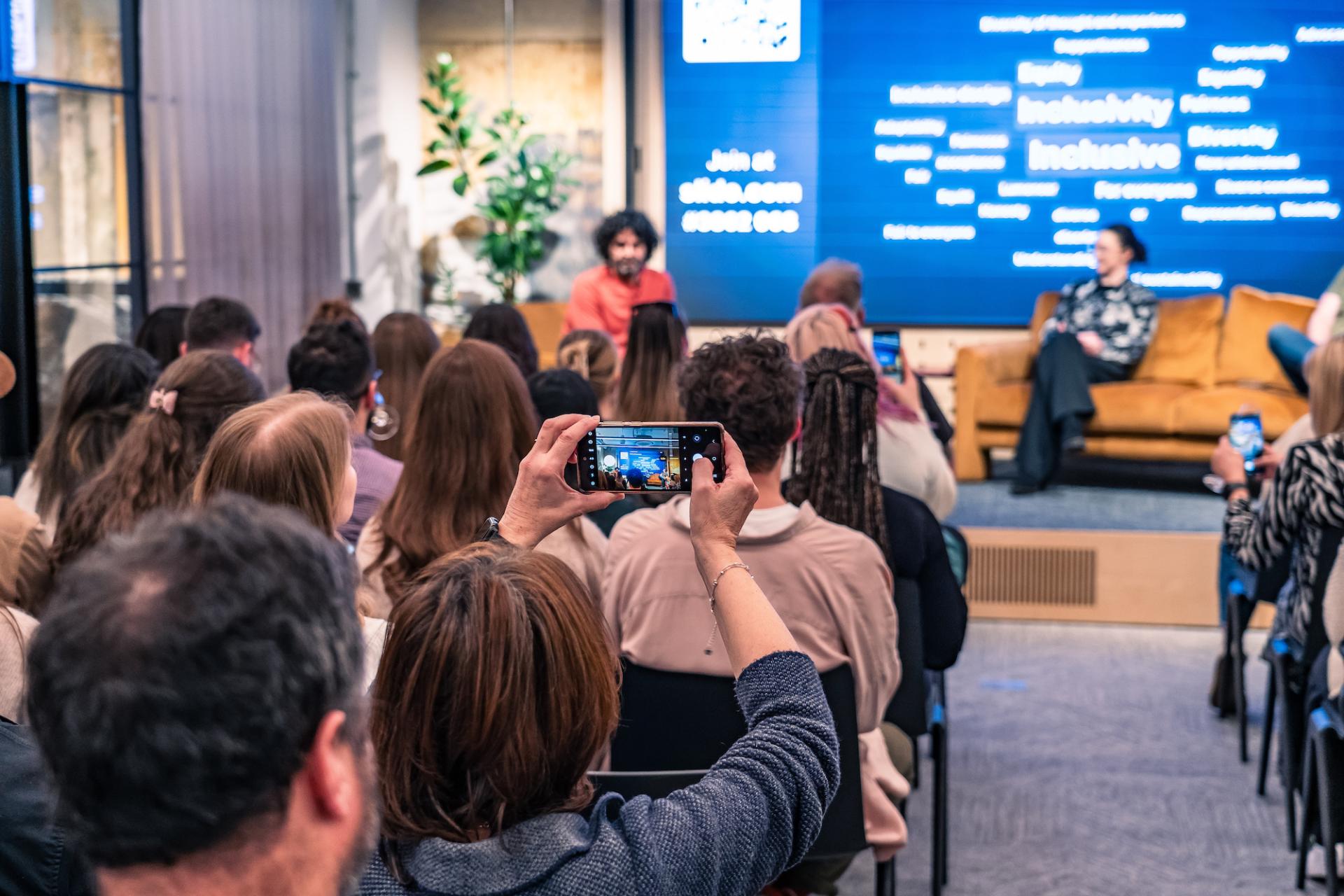 Person takes a photo of the screen at a seminar