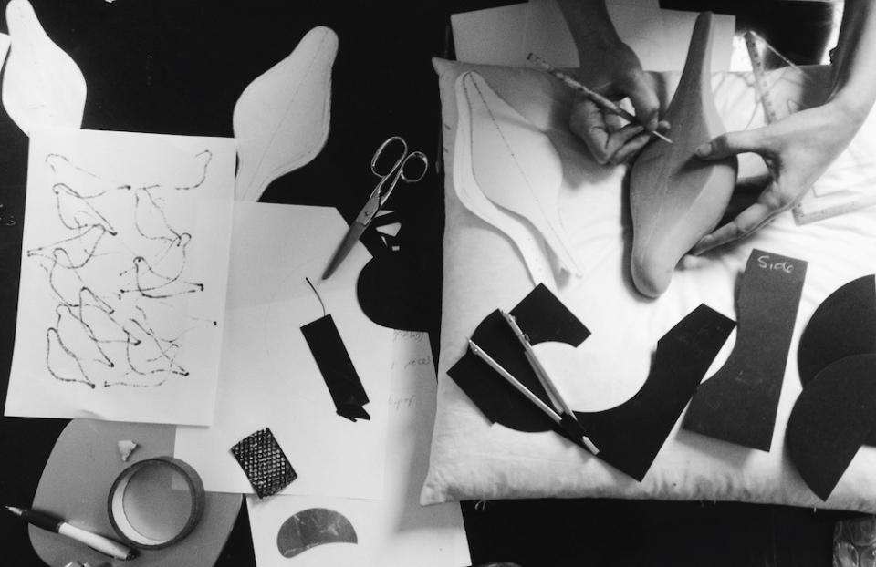 Creative workspace featuring hands designing and cutting various textile patterns and shapes for the May Wild Studio exhibition.