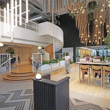 Modern social hub at Eden, New Bailey featuring lighting, greenery, and collaborative spaces promoting community interaction.