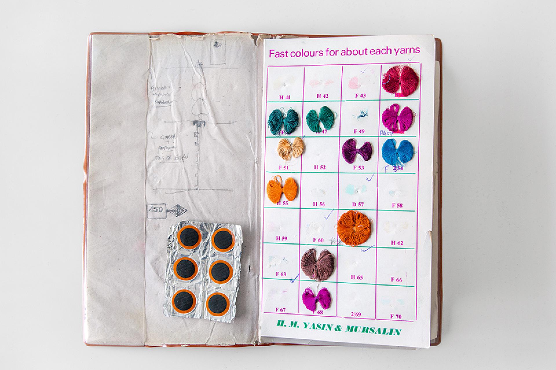 Colorful yarn samples displayed on a notebook page, showcasing various textile hues essential for Kvadrat's design process.