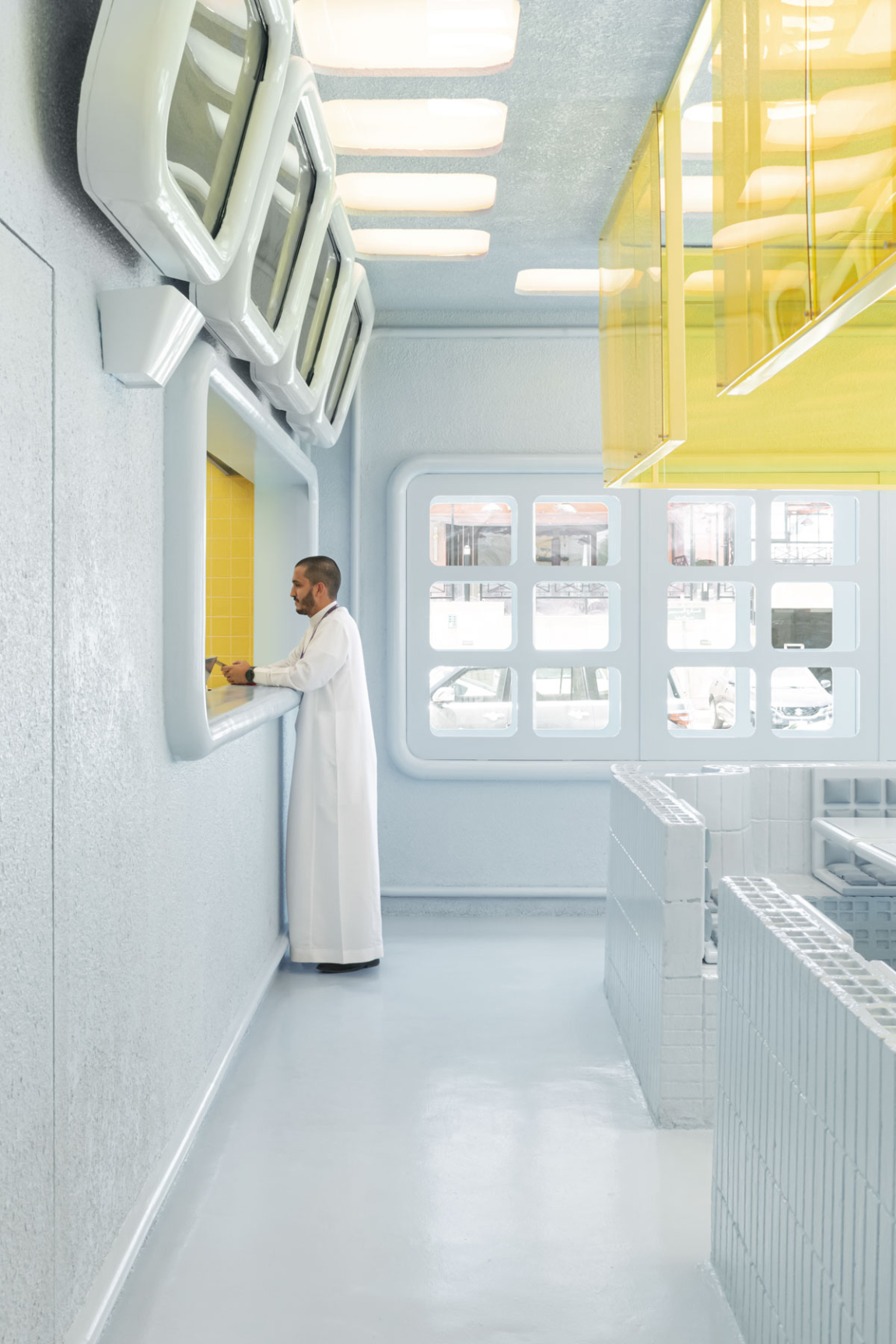 Futuristic interior of Novu Waffle featuring avant-garde design elements and a customer interacting at a service window.