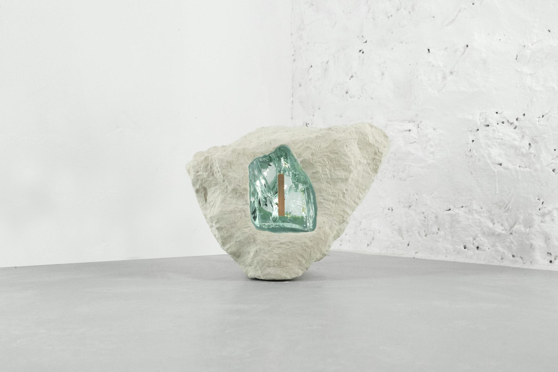 Artistic sculpture featuring a textured stone with a translucent green crystal, showcased at Paris Design Week's Matérialité collection.