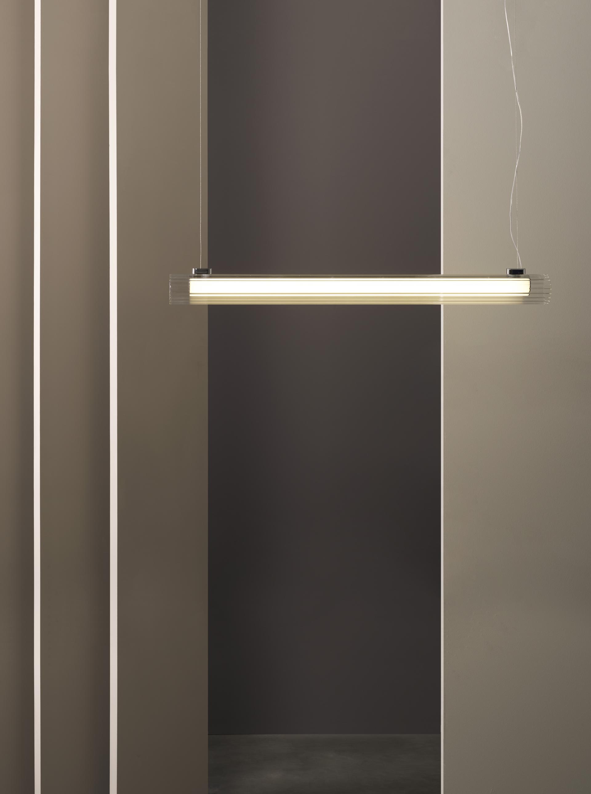 Sleek contemporary pendant light hangs between minimalist walls, showcasing Astro Lighting's design-led capsule collection.