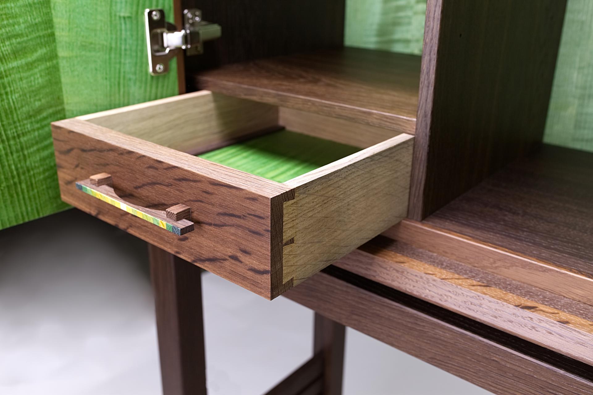 Elegant wooden cabinet drawer showcasing exquisite craftsmanship by Kevin Stamper, highlighting vibrant green accents and fine detailing.