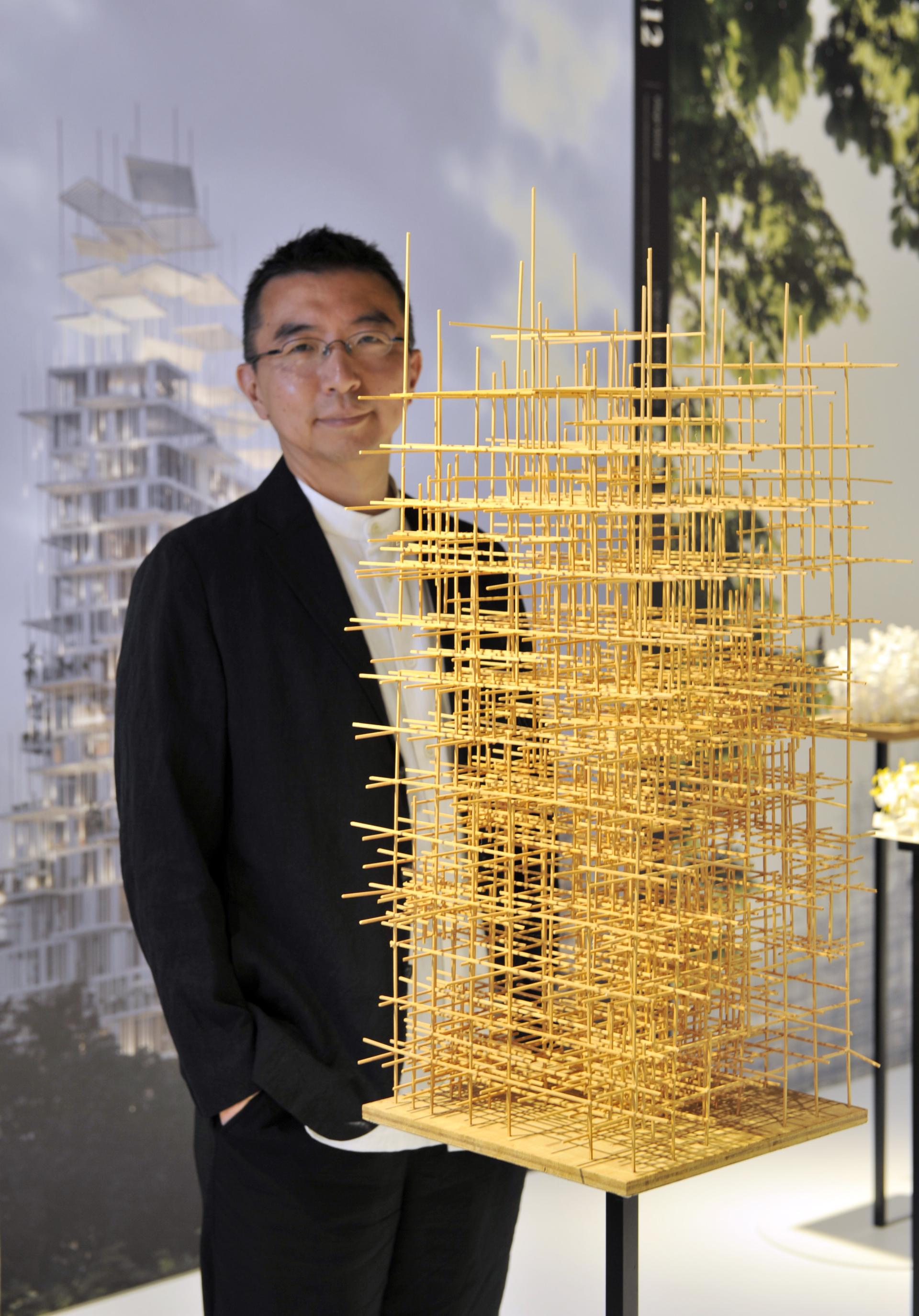 Sou Fujimoto stands beside an intricate architectural model at the opening exhibit of Japan House London.