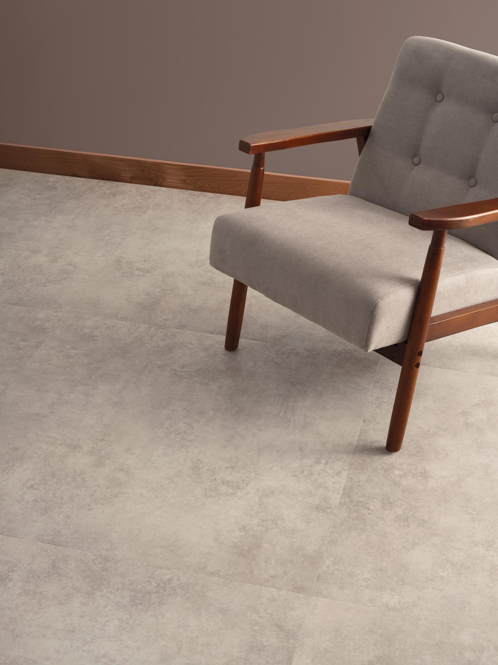 Bio-attributed LVT flooring showcased alongside a modern gray chair, emphasizing sustainable materials in interior design.