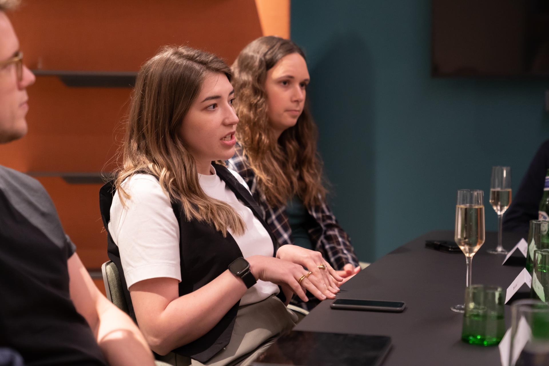 Participants engaged in a discussion about technology's impact on the workplace, with drinks on the table.