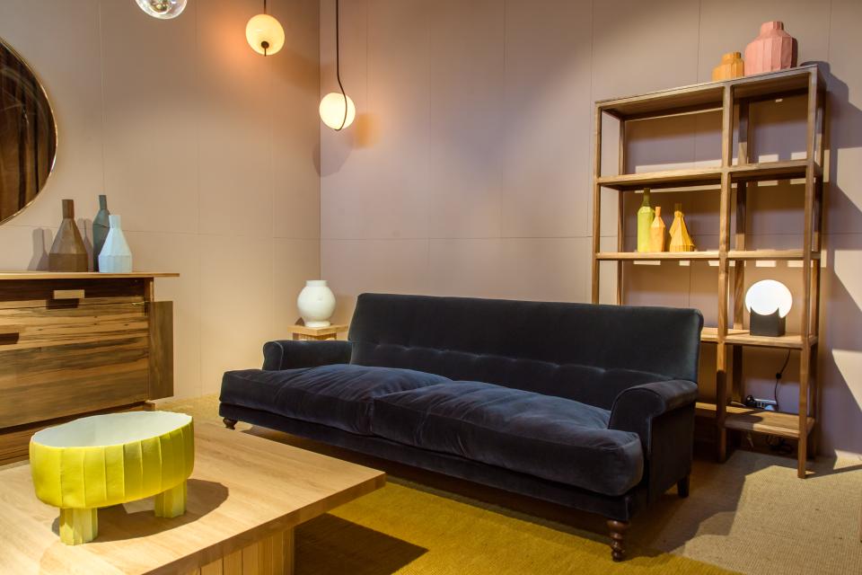 Stylish showroom interior featuring a velvet sofa, wooden furniture, and colorful decor at SCP Pimlico Road in Belgravia.