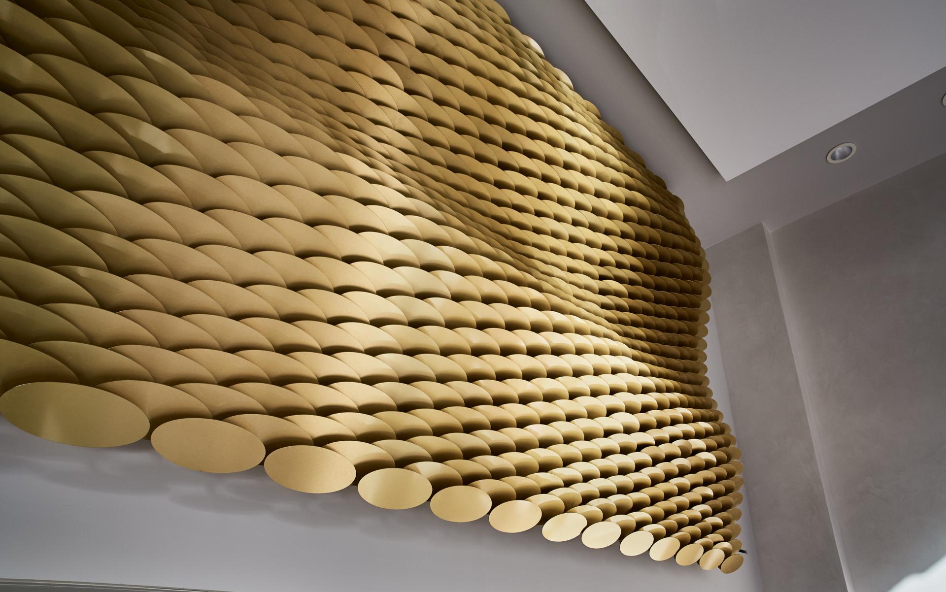 Golden textured wall sculpture in Maggie's St Barts, recognized as Supreme Winner at Surface Design Awards 2019.