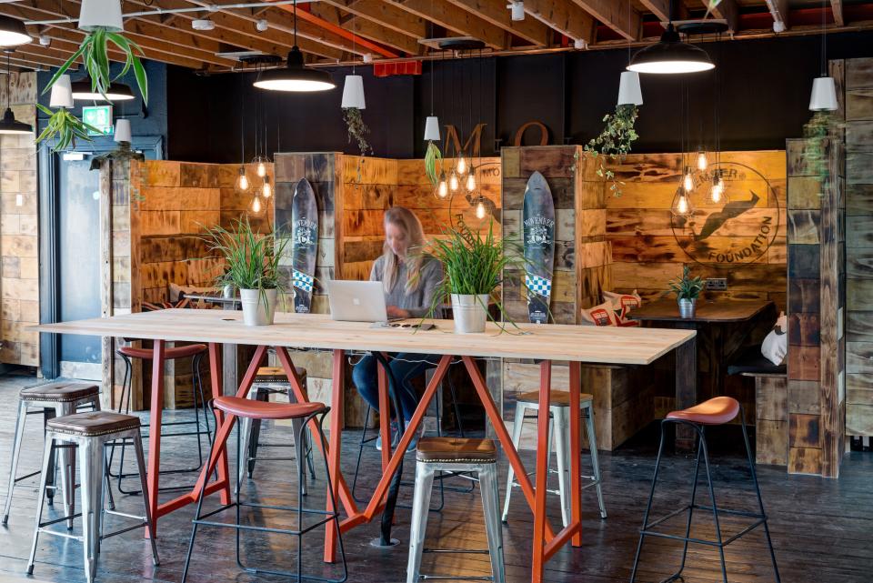 Modern office space at Movember Foundation, featuring plants, wooden decor, and collaborative work areas designed by CCWS Interiors.