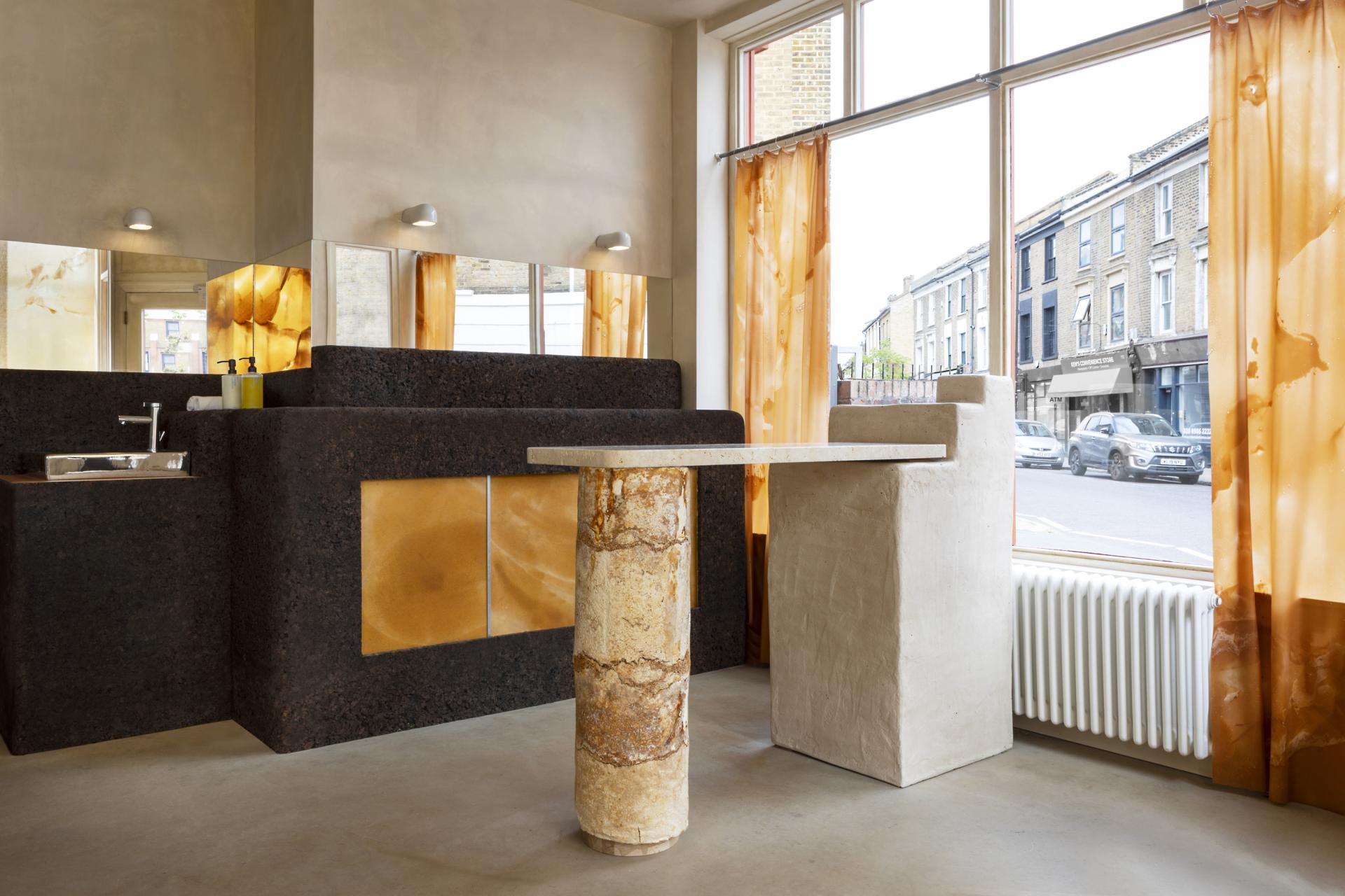 Innovative interior featuring salvaged materials, circular design elements, and bright orange curtains in a sustainable store setting.