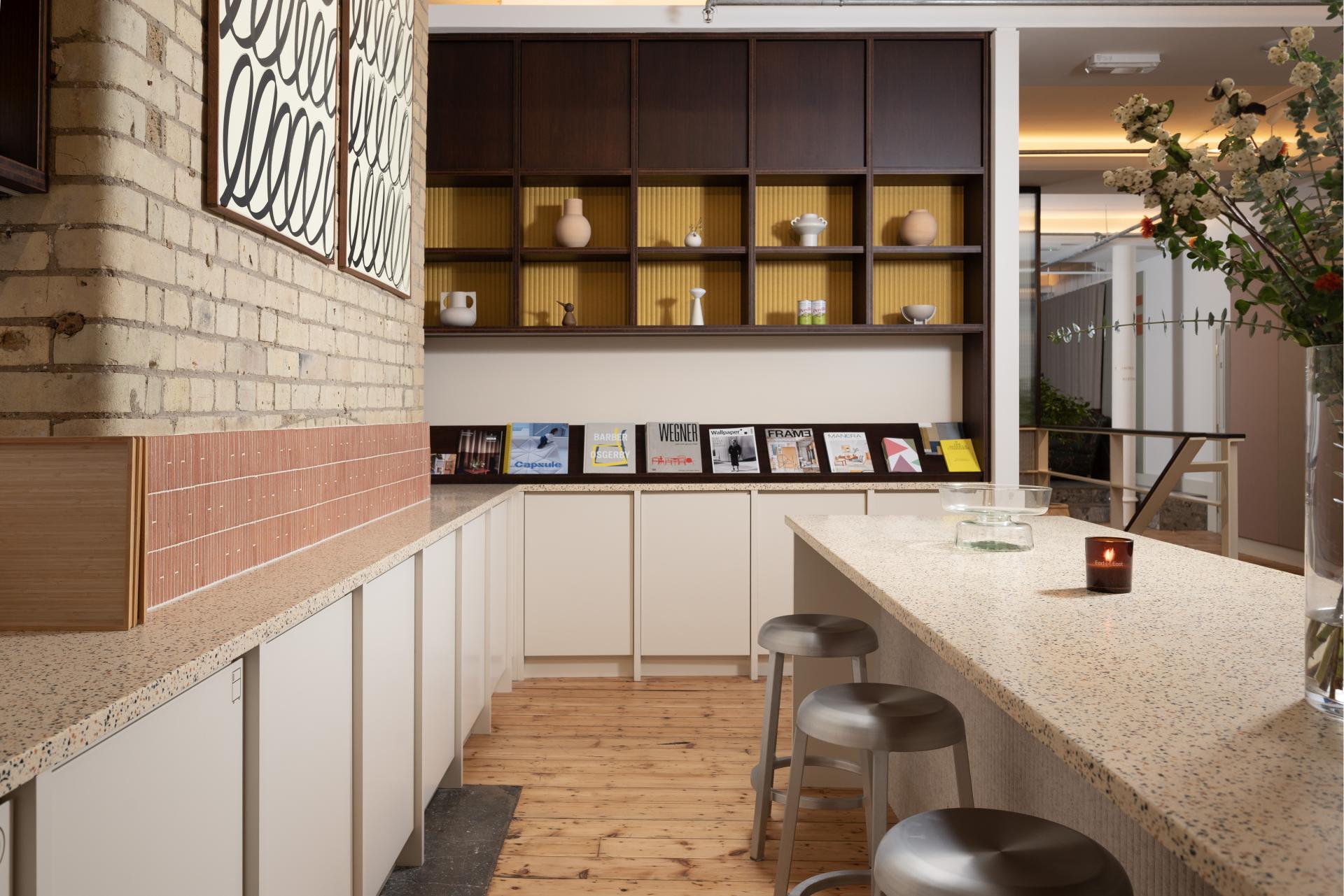 Modern interior design featuring a light-filled space with textured surfaces, display shelves, and vibrant decor elements.