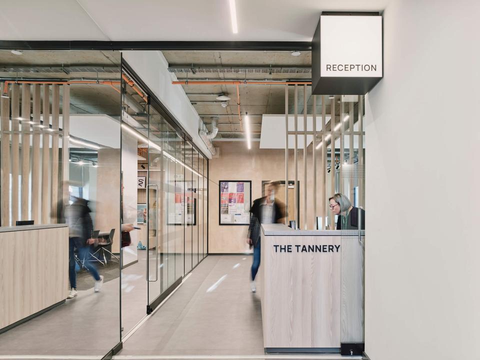 Modern reception area of The Tannery, a student living facility in Leicester, featuring glass partitions and contemporary design.