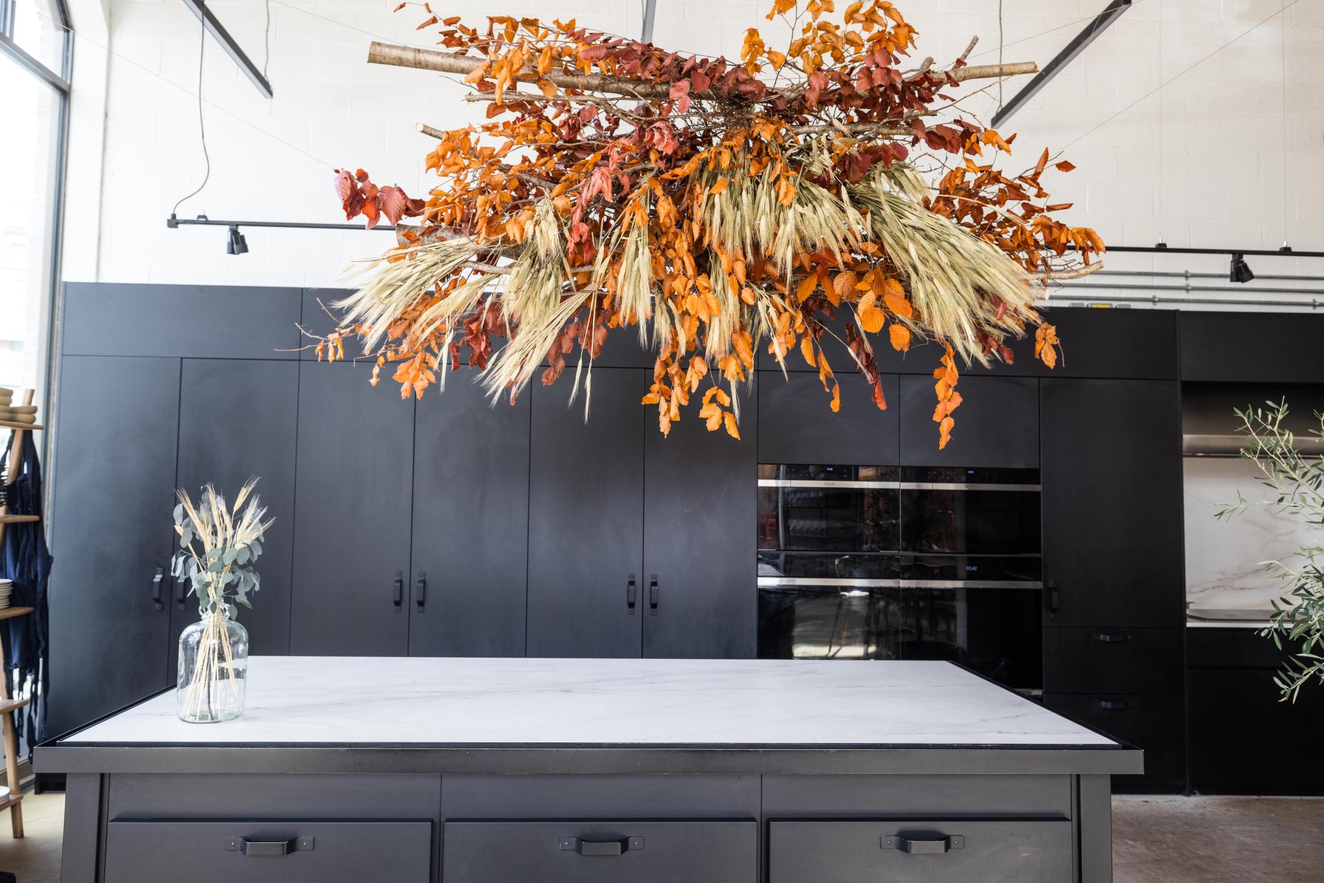 Stylish restaurant interior featuring a large floral installation and sleek black cabinetry at The Water House Project.