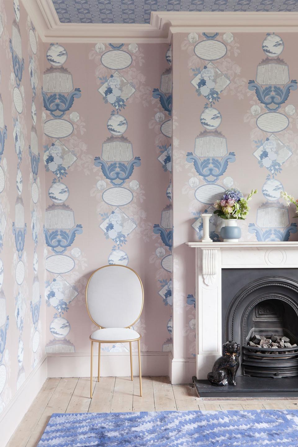 Charming interior of a stylish work/live space featuring unique wallpaper, a modern chair, and a decorative fireplace.