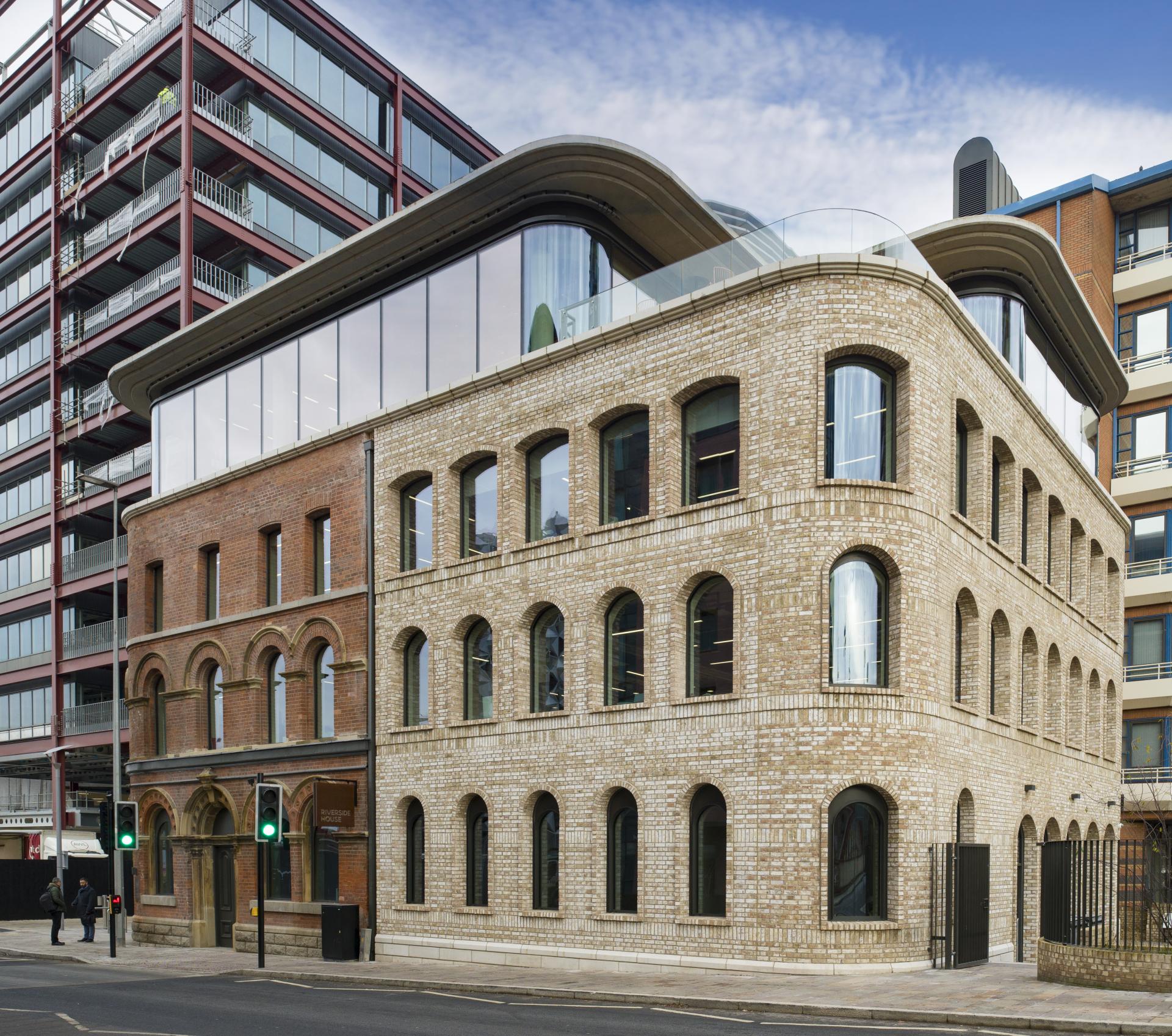 Contemporary Riverside House in Salford features modern architecture complemented by historic brick detailing, designed by SpaceInvader.